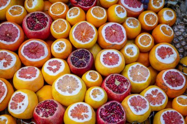 İstanbul sokak pazarında taze sıkılmış meyve suyu almak için olgun portakallar ve el bombaları. Hindi. Kapat.