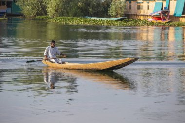 Srinagar, Hindistan - Temmuz 02, 2015: Dal Gölü 'nde yaşam tarzı, Hindistan' ın Srinagar, Jammu ve Kashmir eyaletlerinde küçük bir taşımacılık teknesi olan Shikara 'yı kullanıyor. Teknedeki Hintli adam.
