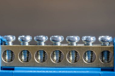 Elektrik kontrol kabinindeki nötr kabloları birbirine bağlamak için bronz cıvatalar takılı, yakın çekim, makro, kopyalama alanı