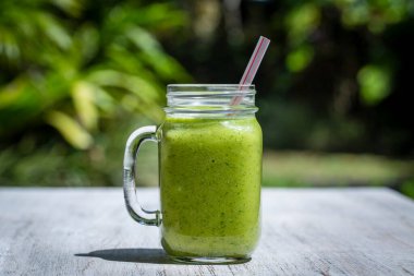Taze smoothies avokado, muz, mango ve bal Beyaz ahşap tablo üzerinden. Ada Bali Ubud, Endonezya. Açık havada, kapatmak