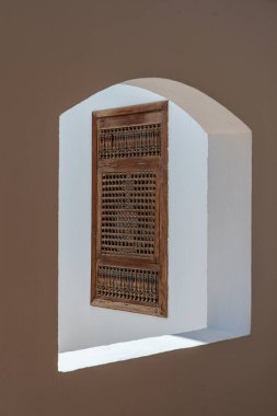 Sharm El Sheikh 'te, Mısır caddesinde eski beyaz bir duvarda, ahşap parmaklıklar olan kapalı bir pencere.