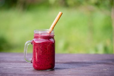 Masadaki cam bardakta nefis yaban mersinli smoothie.