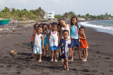 Children group portrait on the beach with volcanic sand near Mayon volcano, Philippines clipart