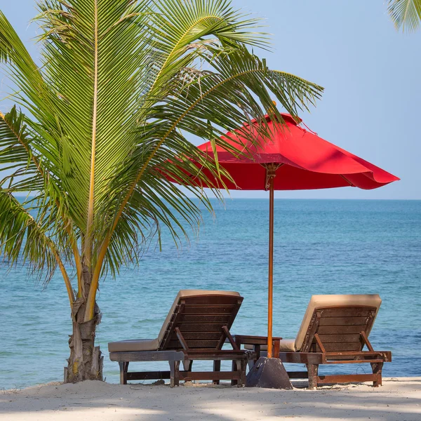 Plaża dwa krzesła, czerwony parasol i palmy na plaży w Tajlandii — Zdjęcie stockowe