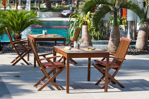 Tafel en stoelen in lege café naast het zwembad — Stockfoto