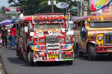 Jeepneys passing, Filipino inexpensive bus service. Philippines. clipart