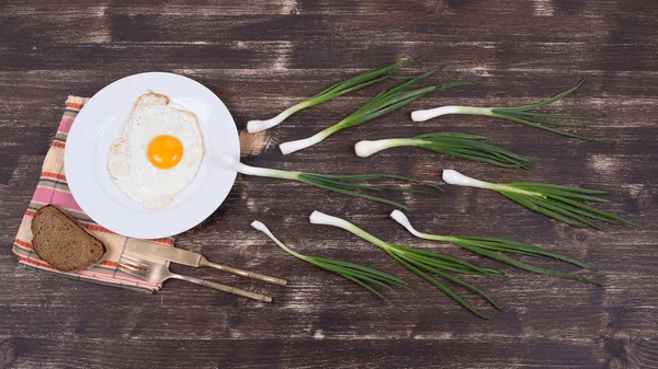 Œufs, ciboulette et plaque noire ressemblent à la compétition de sperme, spermatozoïdes flottant à l'ovule — Photo