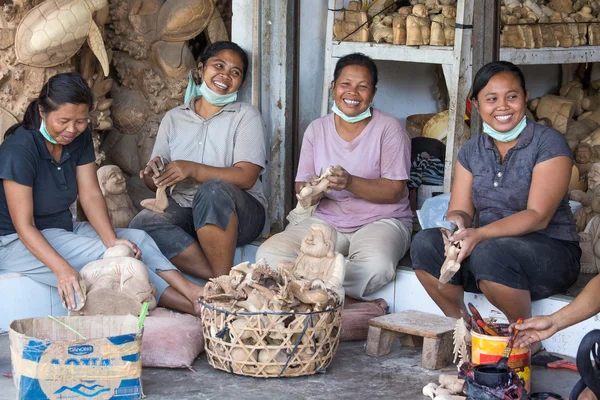Women are making wooden souvenirs for tourists in Bali