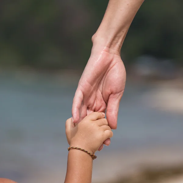 Hände von Mutter und Kind am Strand — Stockfoto
