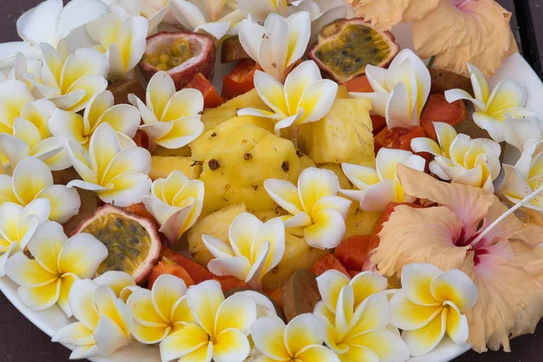 Dessert fruitsalade met ananas, papaja, passievruchten en witte frangipani bloem — Stockfoto