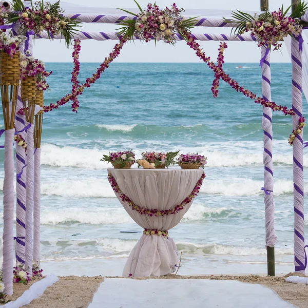 Arco di nozze decorato con fiori sulla spiaggia di sabbia tropicale, allestimento di matrimoni sulla spiaggia all'aperto — Foto Stock