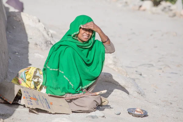 Arme vrouw smeekt om geld uit een voorbijganger in Leh. India — Stockfoto