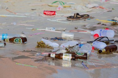 Consequences of sea water pollution on the beach after the full moon party. Island Koh Phangan, Thailand clipart