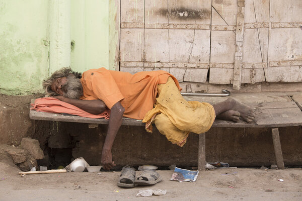 Indian homeless man sleeps on the street. Pushkar, India