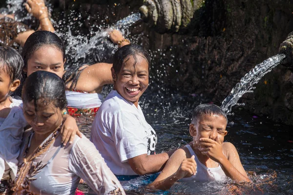 巴厘岛的家庭来对神圣的温泉水寺的 Tirta Empul 在巴厘岛，印度尼西亚祈祷，净化他们的心灵 — 图库照片