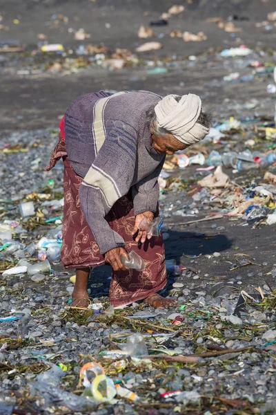 Old poor woman  about to trash plastic products to Bali island.Indonesia — Stock Photo, Image