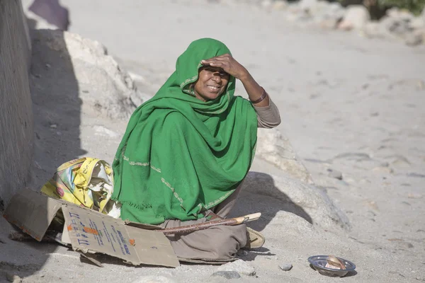 Eine arme Frau bettelt bei einem Passanten in Leh um Geld. Indien — Stockfoto