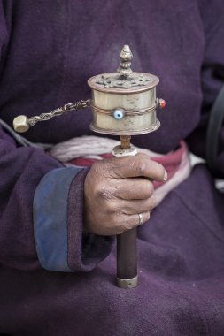 Old Tibetan man holding buddhist prayer wheel, Ladakh, India