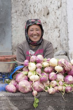 Smiling Tibetan woman sells vegetables at the market in Leh, Ladakh. India