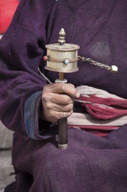 Old Tibetan man holding buddhist prayer wheel, Ladakh, India