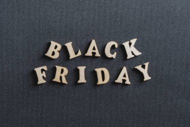 Siyah arka planda siyah Cuma yazılı ahşap harfler, yakın plan, üst manzara. Mağazalarda terfi ve satış zamanı.