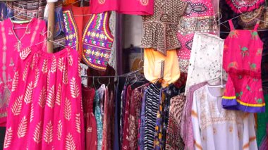Udaipur, Rajasthan, Hindistan 'daki yerel sokak pazarında satılık renkli kıyafetlerin çeşitli ürünleri. Kapat.