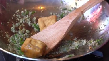 Kızartma tavası, doğranmış sarımsak, yeşil biber ve soya peyniri, yakın çekim. Endonezya 'da. Endonezya geleneksel yemekleri