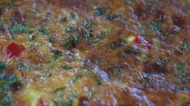 Sebzeli frittata ile seramik kase, basit vejetaryen yemeği. Tahta masada domates, biber, soğan ve peynirli frittata, yakın çekim. İtalyan omleti, sırayla.