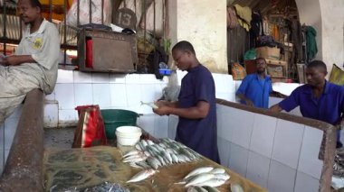 Zanzibar, Tanzanya - Kasım 03, 2019: Afrikalı erkekler Doğu Afrika 'daki Tanzanya' nın Zanzibar adasındaki yerel gıda pazarında taze deniz balığı hazırlayıp satıyorlar.