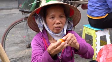Hanoi, Vietnam - Mart 01, 2020: Kadınlar Hanoi, Vietnam 'daki eski bir kasabanın sokak gıda pazarında meyve ve sebze satıyorlar