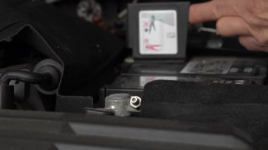 Kırmızı akü kablosu olan araba aküsü güvenli bir şekilde bağlandı, kapat. Şarj kıskacı batarya terminaline. Eski araba aküsü şarj ediliyor.