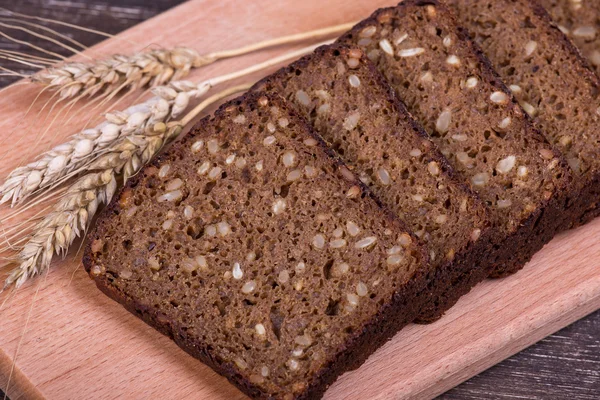 Vers brood en tarwe op het hout — Stockfoto