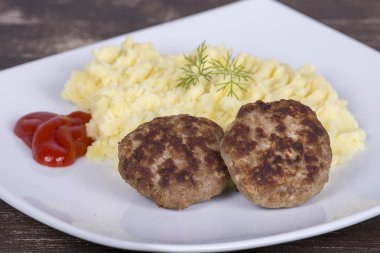Kızarmış pirzola beyaz bir tabak patates püresi ile