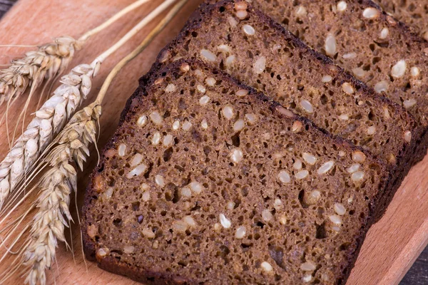 Vers brood en tarwe op het hout — Stockfoto