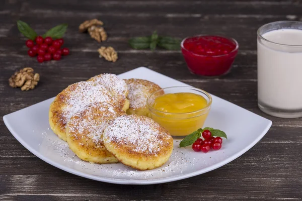Heerlijke huisgemaakte kaas pannenkoeken met honing in witte plaat — Stockfoto