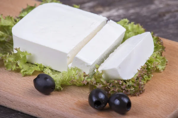 Queijo grego branco tradicional em uma tábua de madeira — Fotografia de Stock