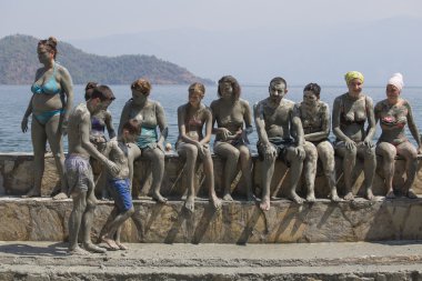People are taking a mud bath. Mud baths are great for the skin. Dalyan, Turkey