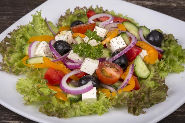 Ελληνική σαλάτα από φρέσκα λαχανικά στο τραπέζι — Φωτογραφία Αρχείου