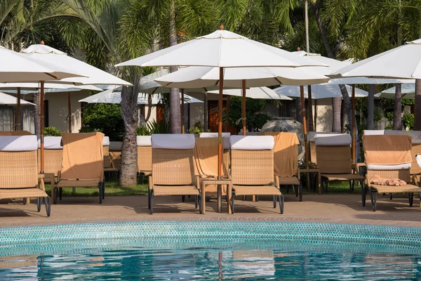 Beach chairs near swimming pool in tropical resort , Thailand. — Stock Photo, Image