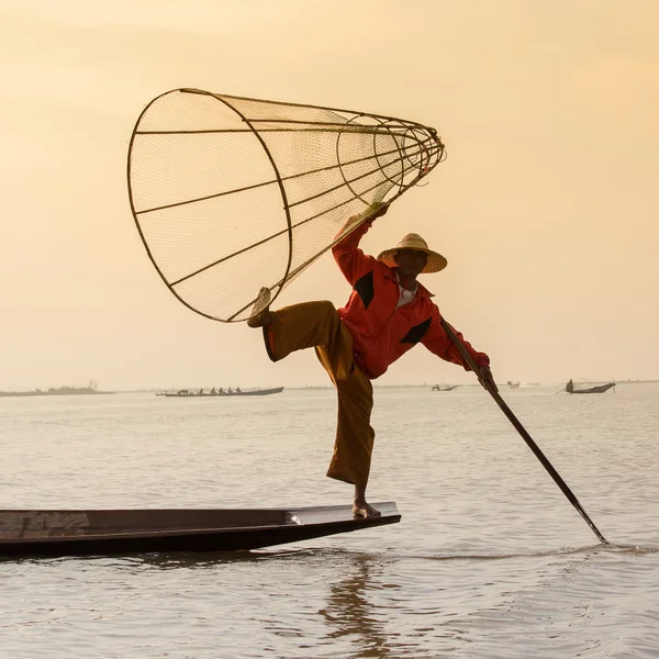 Pescador birmanês em barco de bambu captura de peixe de forma tradicional com rede artesanal. Lago Inle, Mianmar, Birmânia — Fotografia de Stock