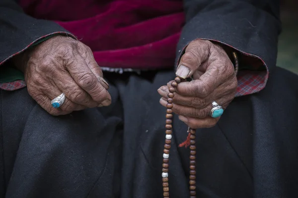 Old Tibetan woman holding buddhist rosary in Hemis monastery, Ladakh, India. — Stock Photo, Image