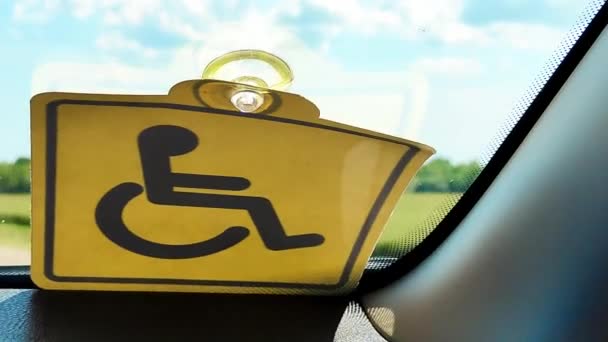 残疾汽车驶过田野.窗户上的黄色标志 — 图库视频影像