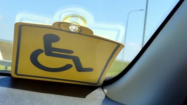 Pessoa com deficiência monta em um carro com um sinal especial para pessoas com deficiência — Vídeo de Stock