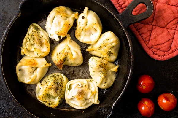 Fried Russian pelmeni with meat in a frying pan. — Stock Photo, Image