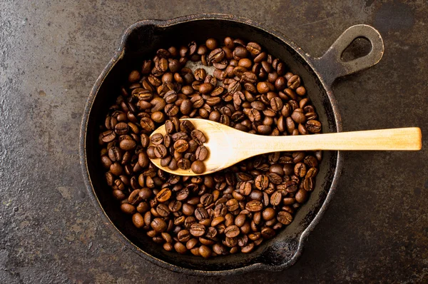 Cuchara tostado granos de café en una sartén —  Fotos de Stock