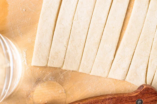 Strips of dough on a cutting board — Stock Photo, Image