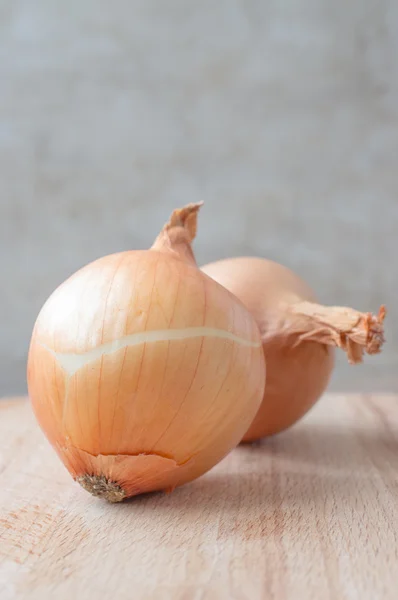 Onions on a wooden board — Stock Photo, Image