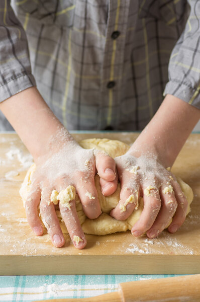 Hands teenage boy prepares the dough