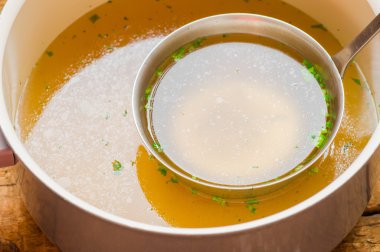 Bouillon bir kepçe ile ile tencere