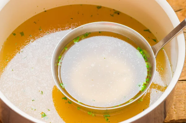 Casserole with meat broth with a ladle — Stock Photo, Image